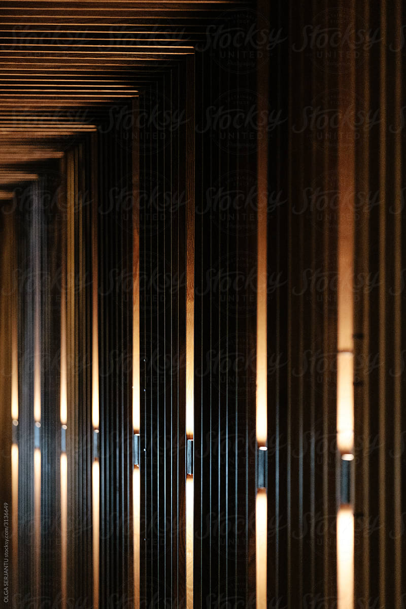 Parallel lights breaking out from a wood wall.