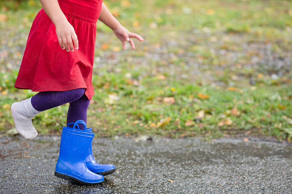 Child in dress stepping into rain boot