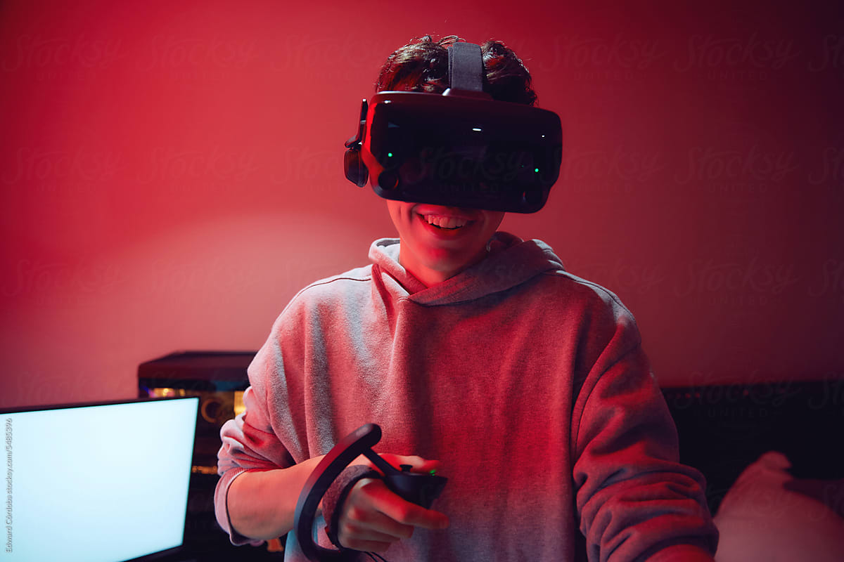 Young man wearing a VR headset immersed in playing video game