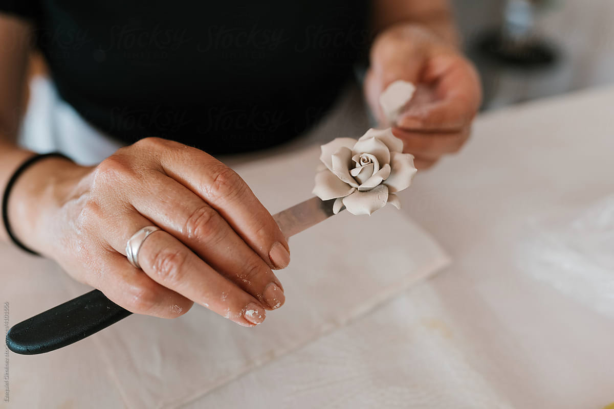 Craftswoman with porcelain flower on knife