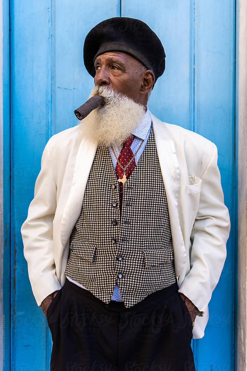 Medium Shot Of Senior Smoking In The Streets Of Cuba.