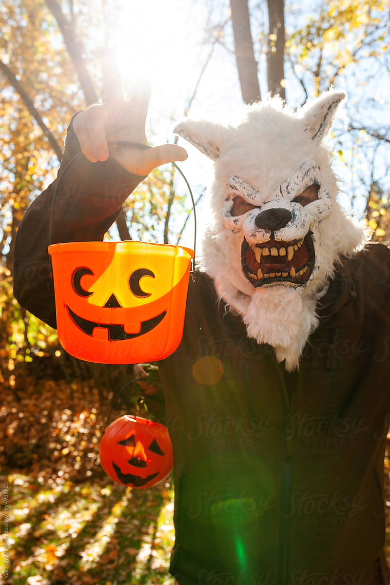 Adult with werewolf mask and pumpkin basket