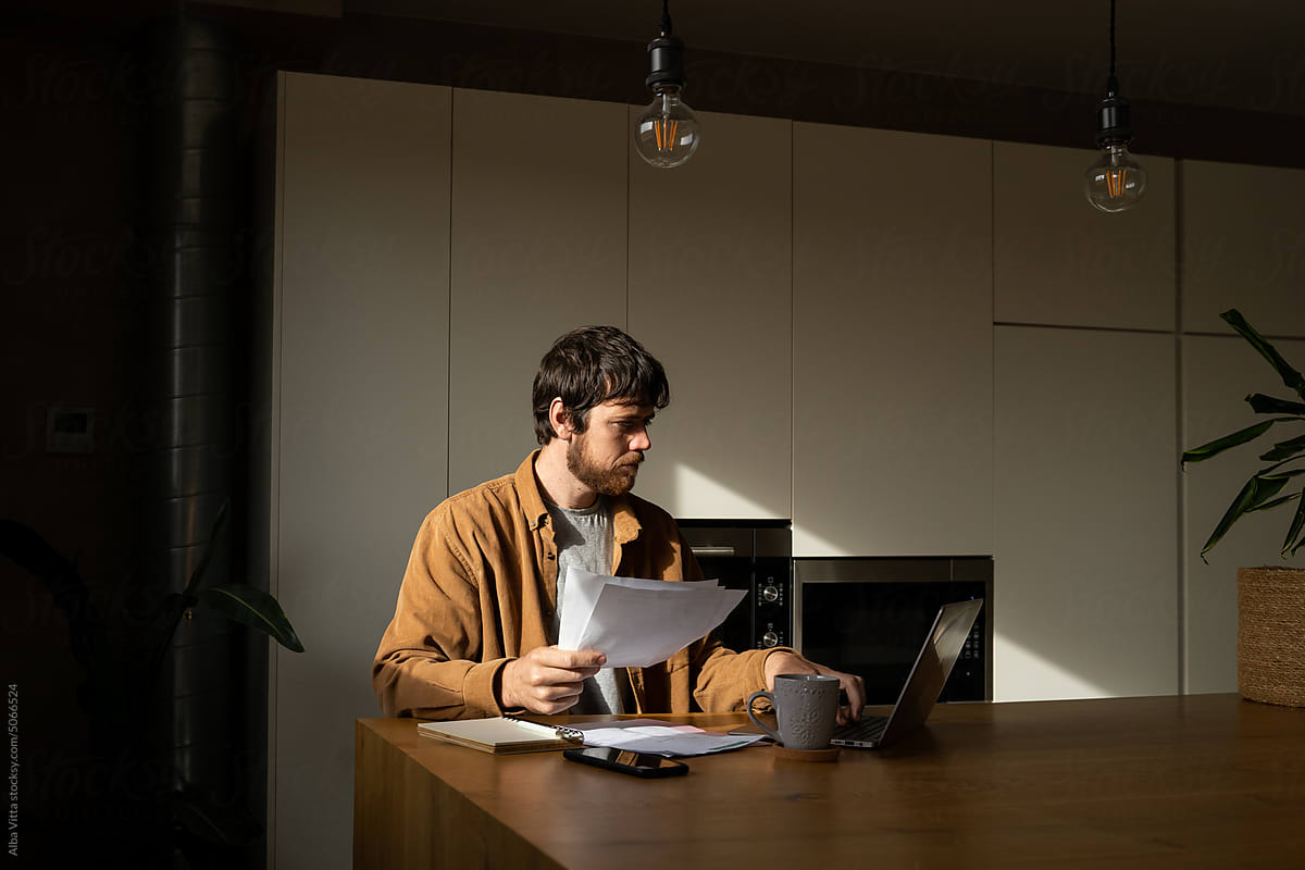 Man paying utility bills and paperwork  from home
