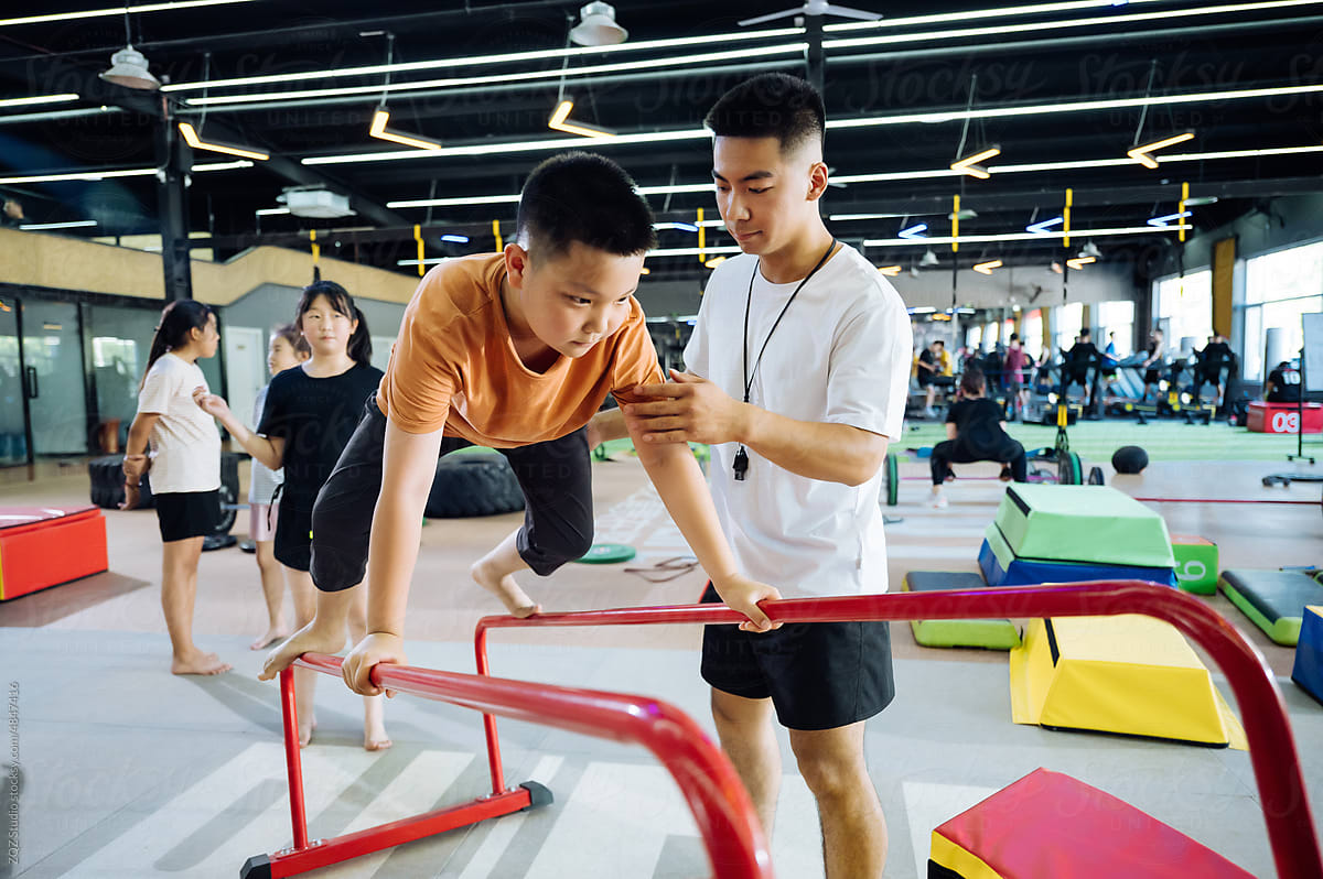 Asian coach instructing young kids