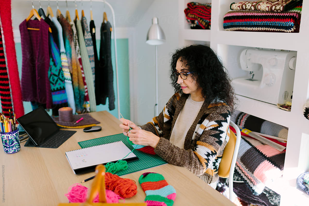 A woman working on knit clothes in a workroom