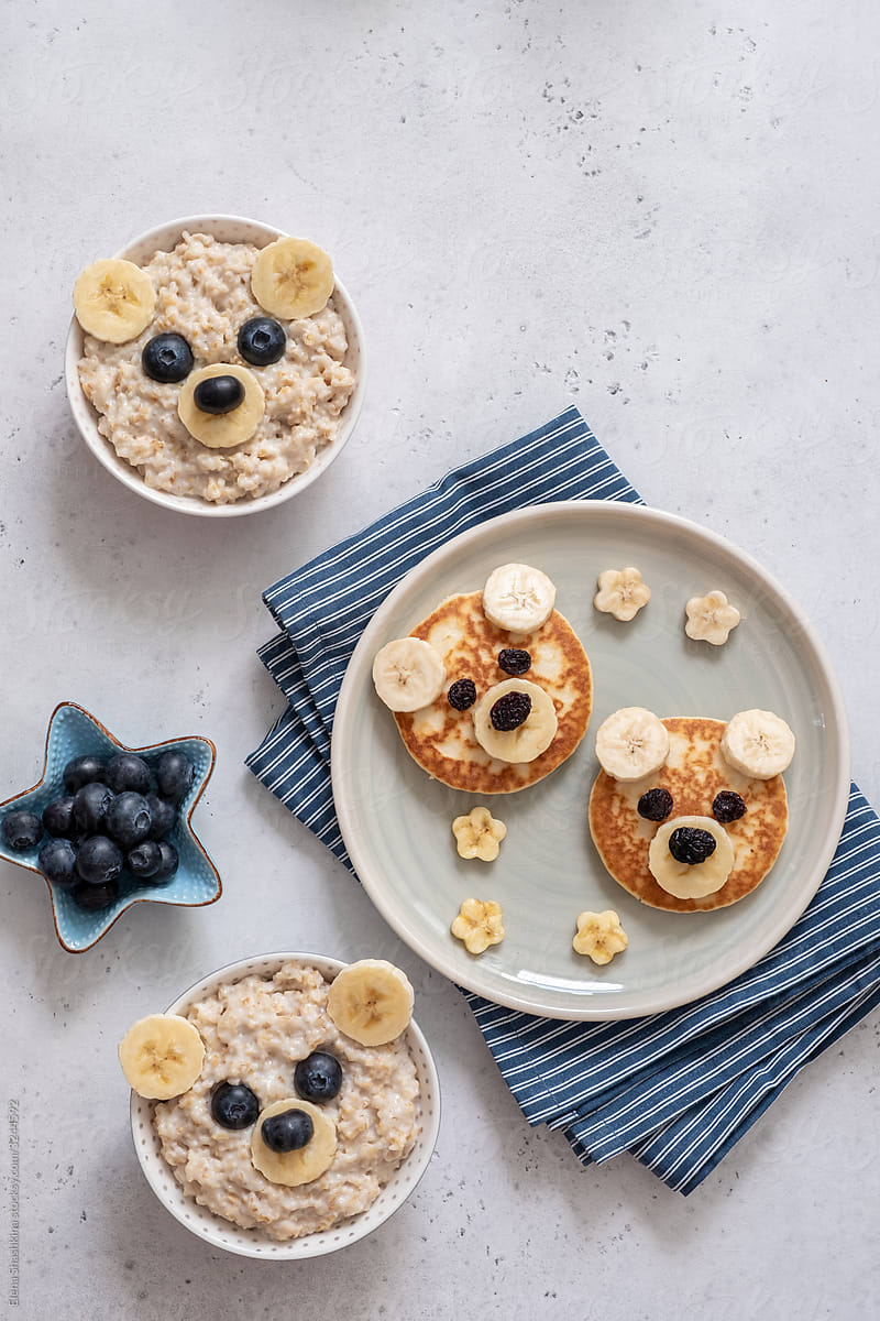 Kids breakfast oatmeal porridge and pancakes with funny bear face