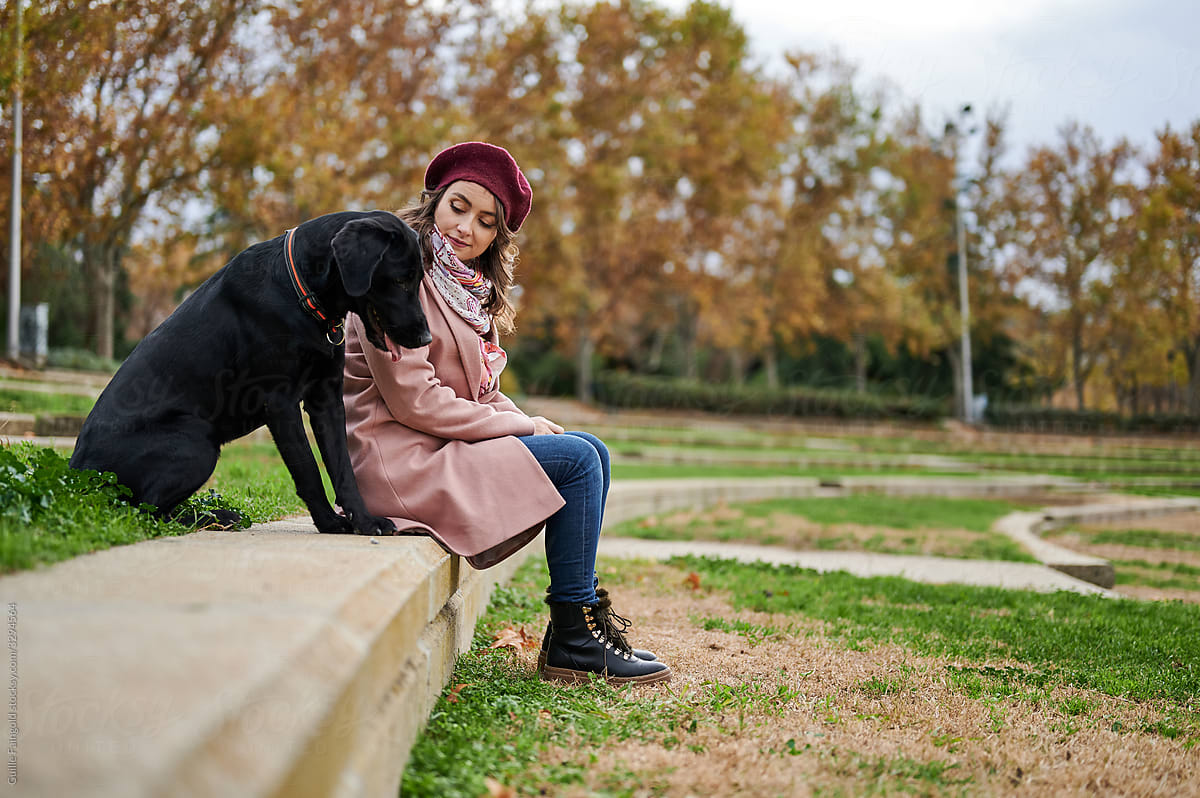 Lady with dog resting in autumn park