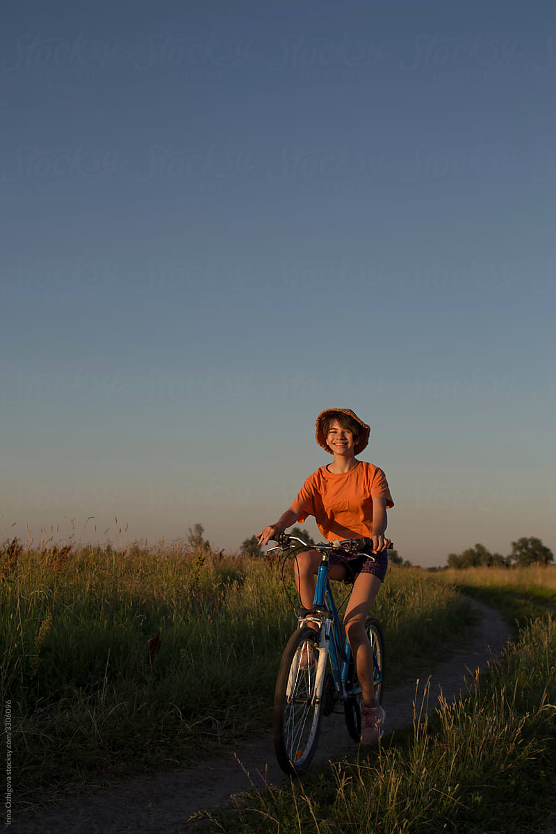 Girl is riding bicycle in a field