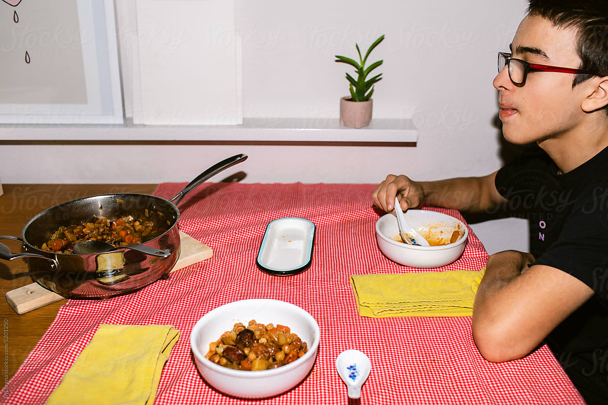 Teenager eating typical spanish food at home
