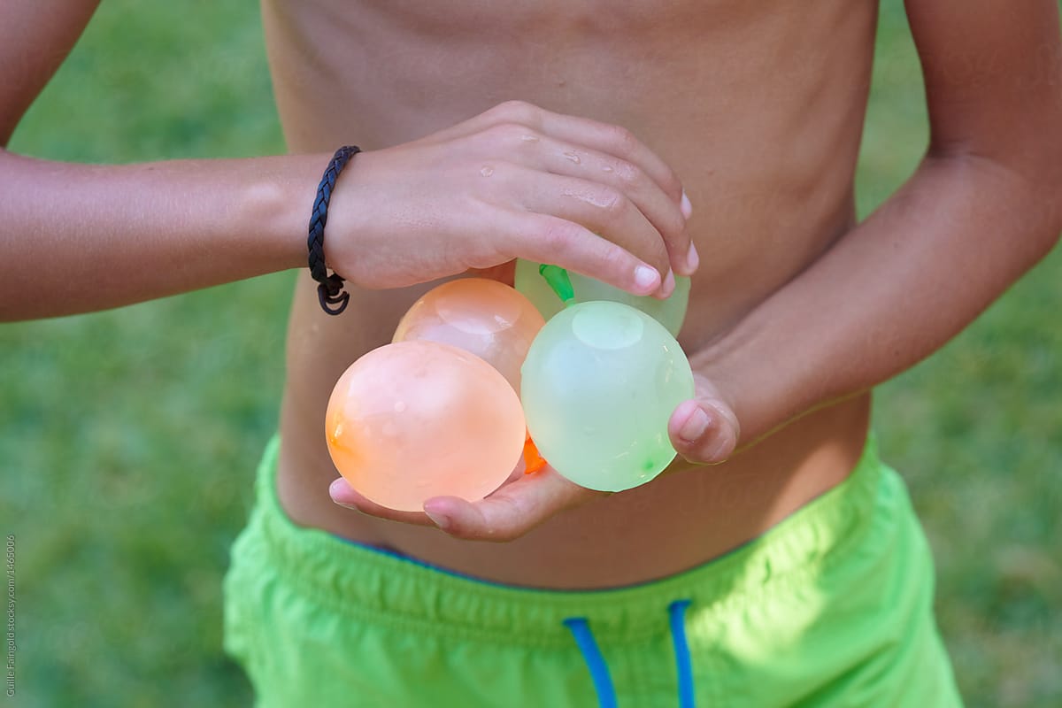 Kid holding several water bombs in hands.