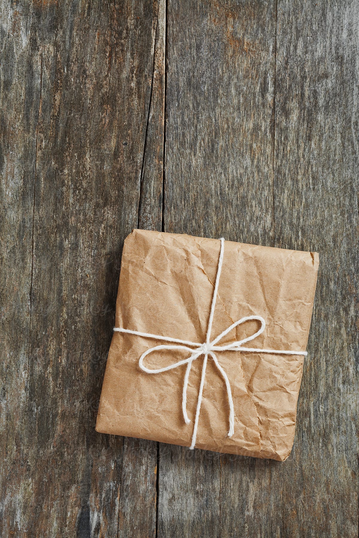 Package wrapped in brown paper on weathered wood