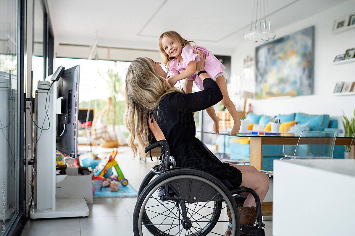 Mother in wheelchair playing with her daughter