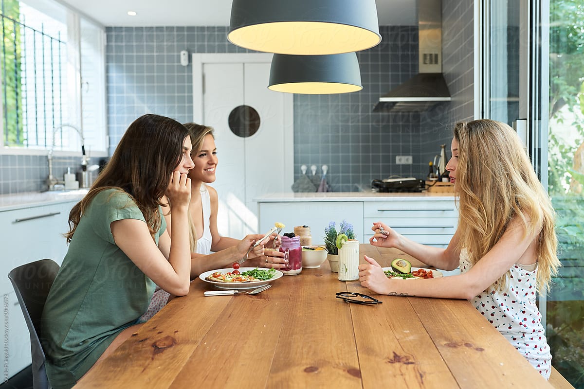 Side View Of Three Friends Having Breakfast In Kitchen By Stocksy Contributor Guille Faingold 2672