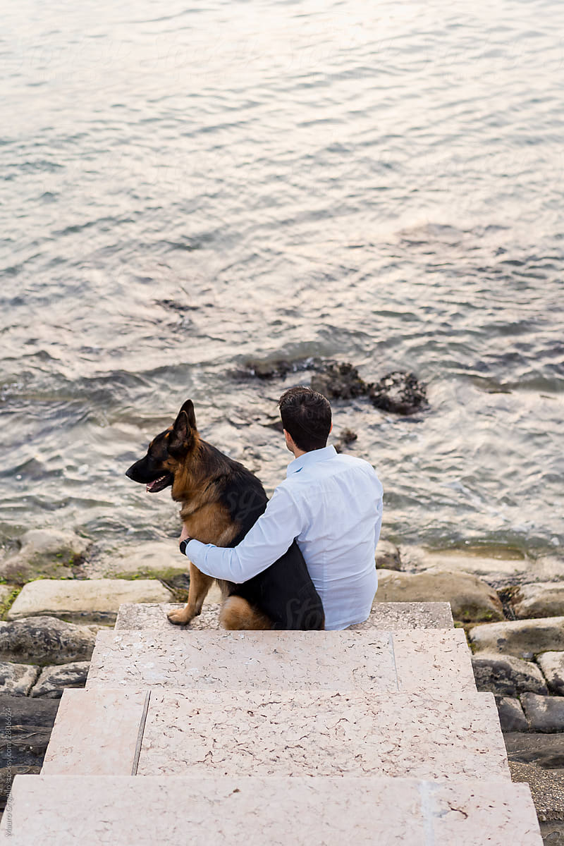 Man sitting with his dog at the seaside