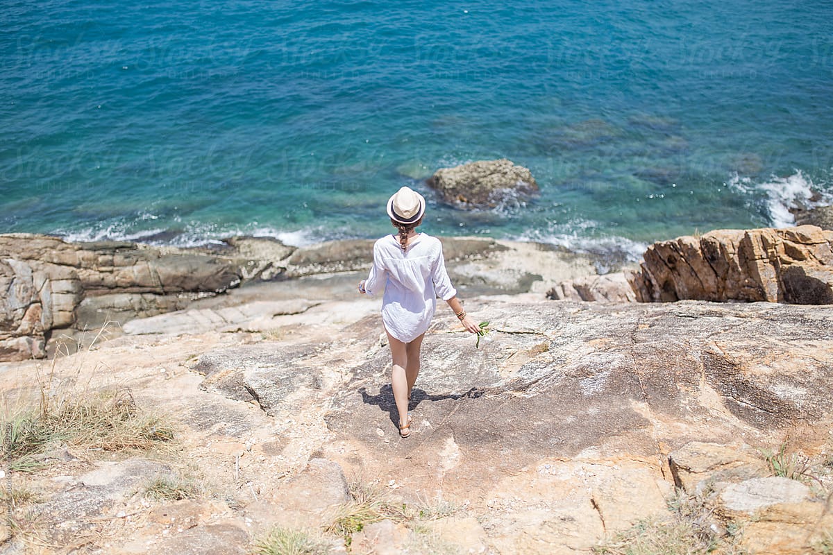 Woman walking towards ocean