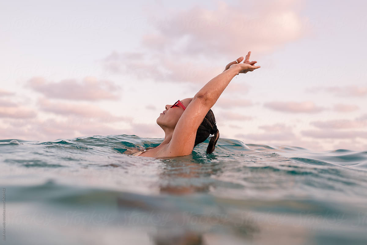 Woman enjoying sea bathe during summer sunset