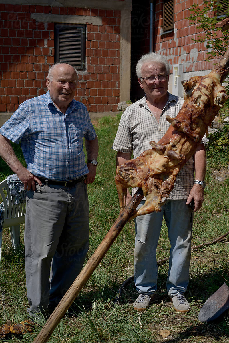 Senior Croatia brothers portrait with roasted lamb