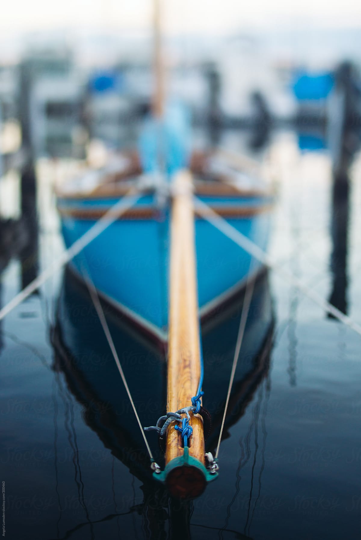 Bow sprit of a moored blue yacht in calm water