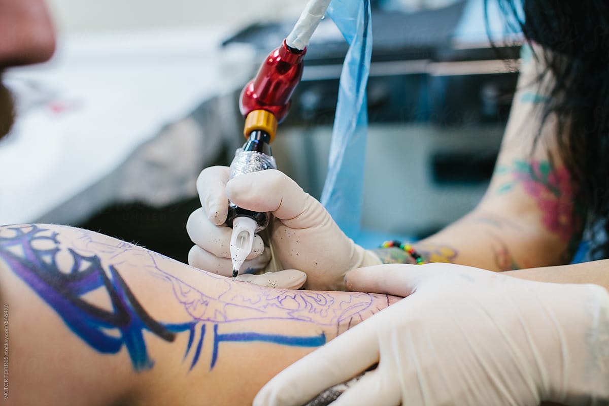Tattoo Artist Working on a Bearded Man\'s Arm