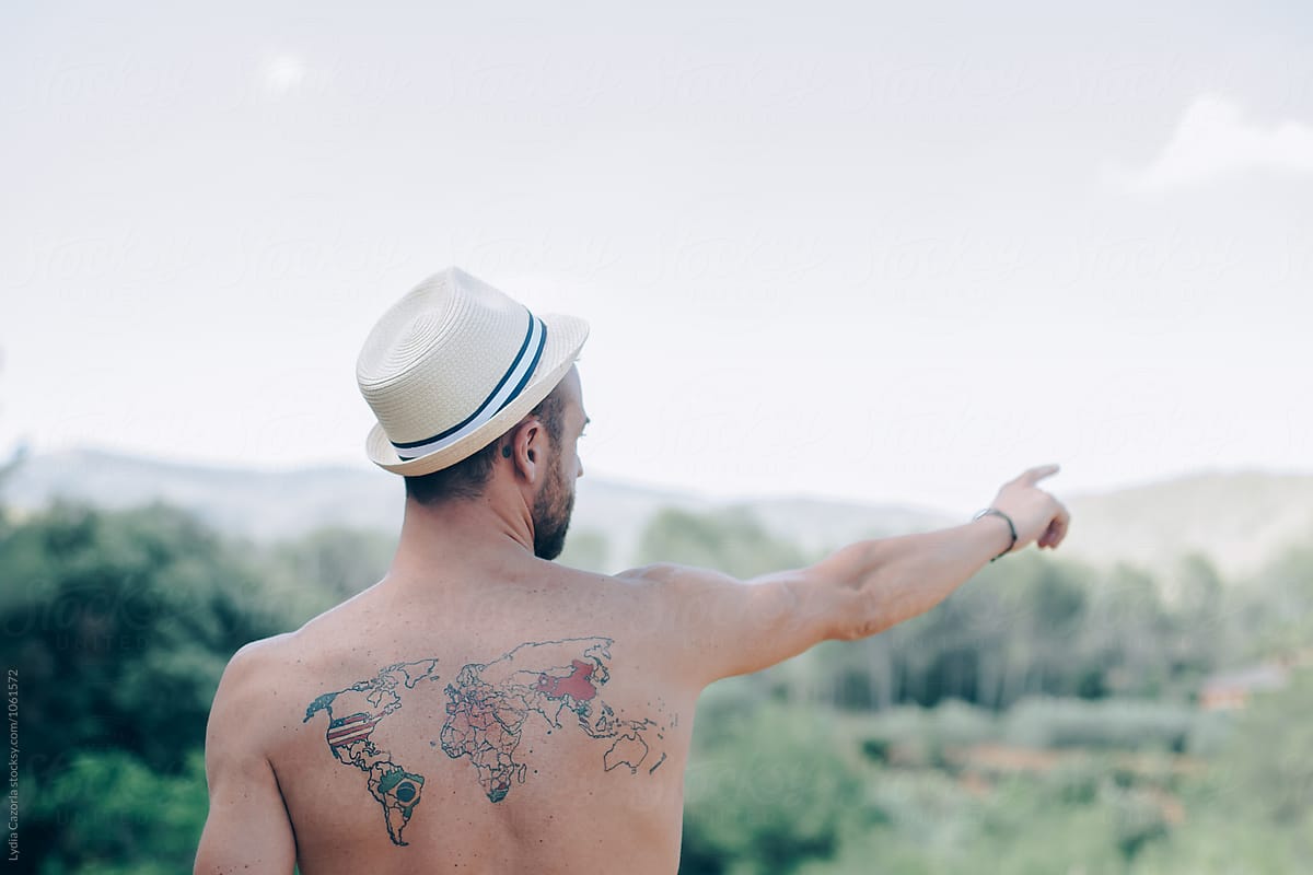A young man with a tattoo on the back of the world map