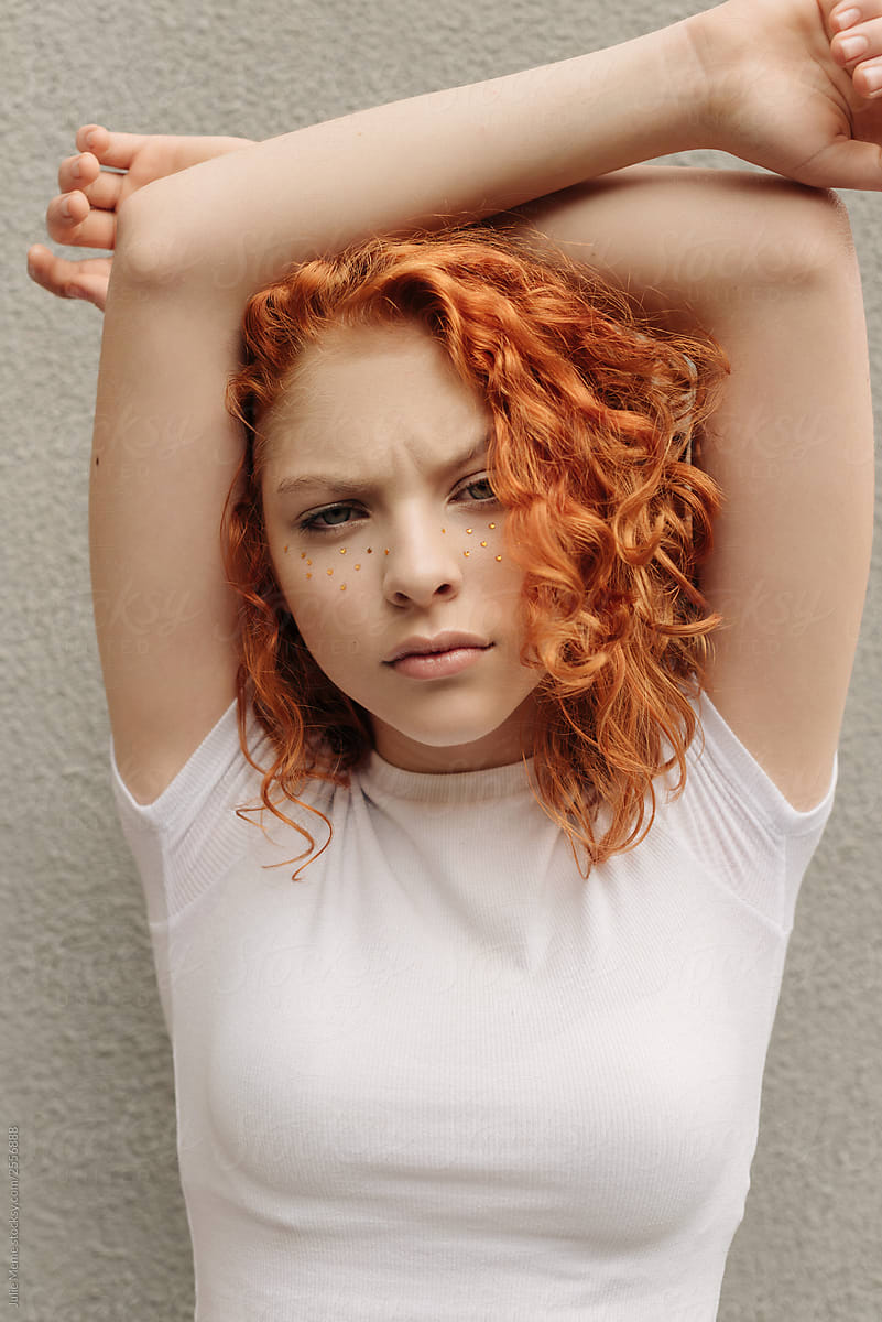 A Curly Red Hair Girl With Fake Freckles Near The Wall By Stocksy