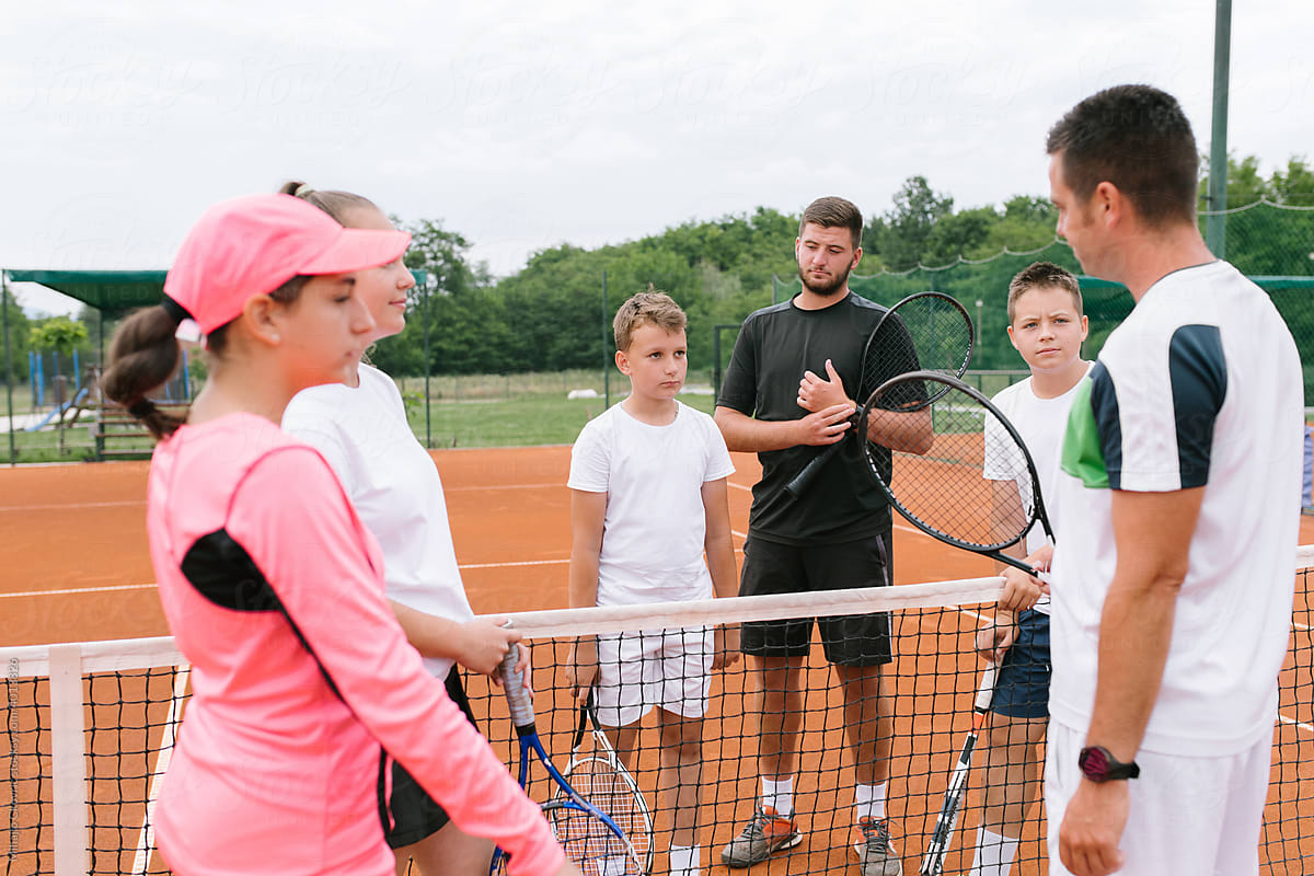 A Tennis Coach Working With His Young Students