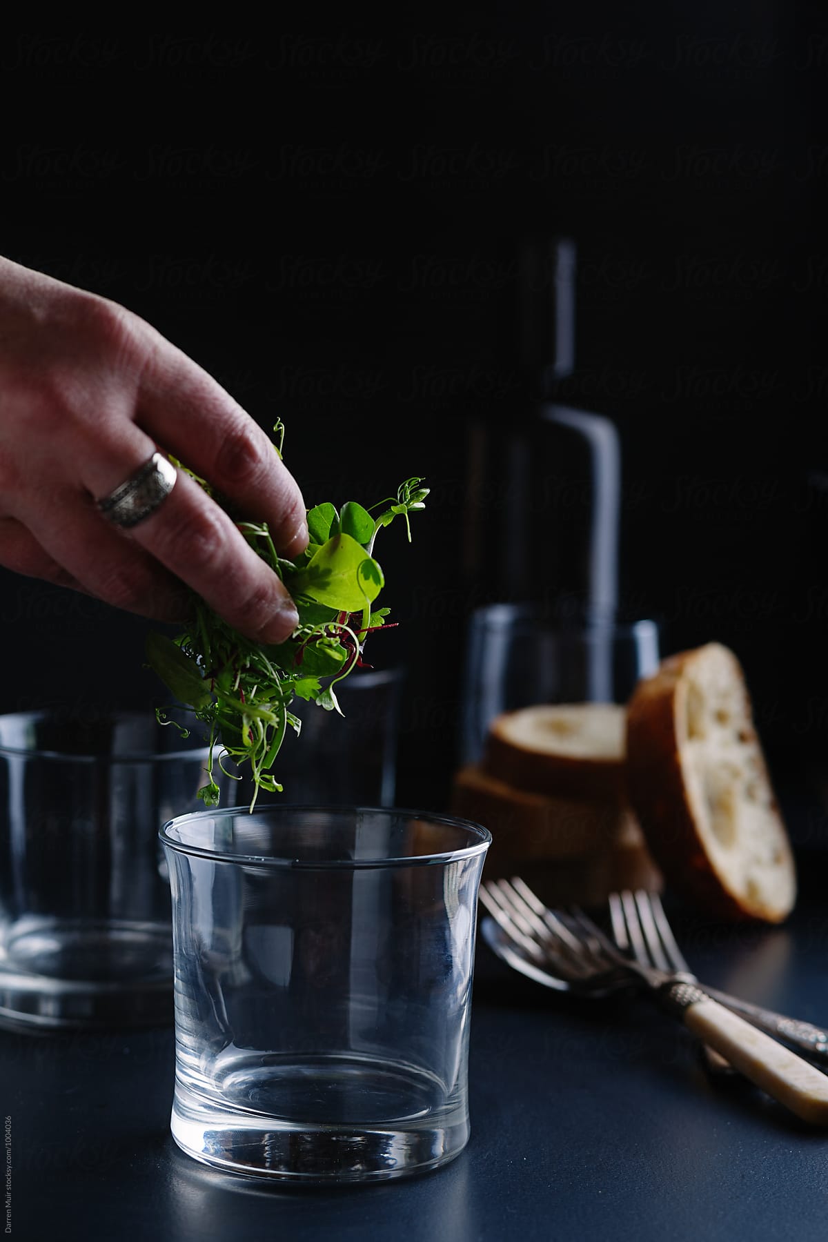 Micro herb salad leaf being put into a glass.