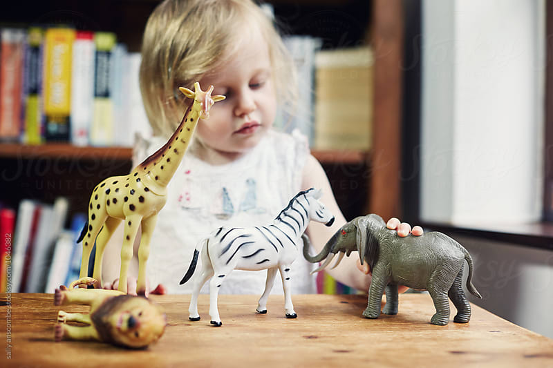 Child playing with toy animals