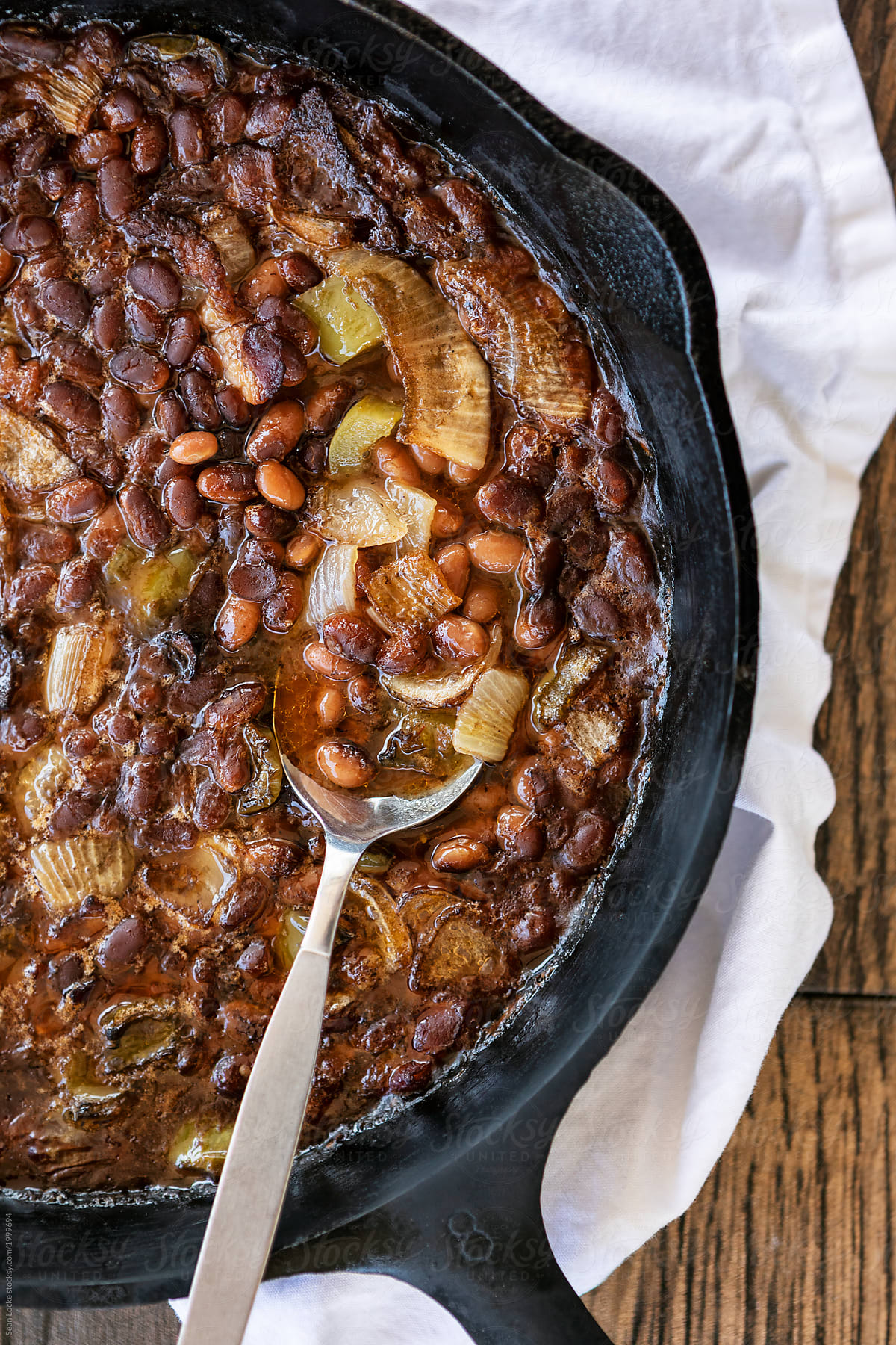 Smoked: Spoon Sits In Cast Iron Pan Of Baked Beans