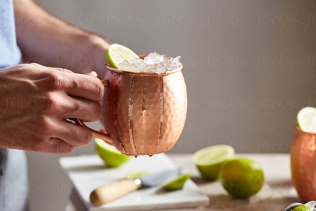 Bartender with fresh Moscow mule cocktail.