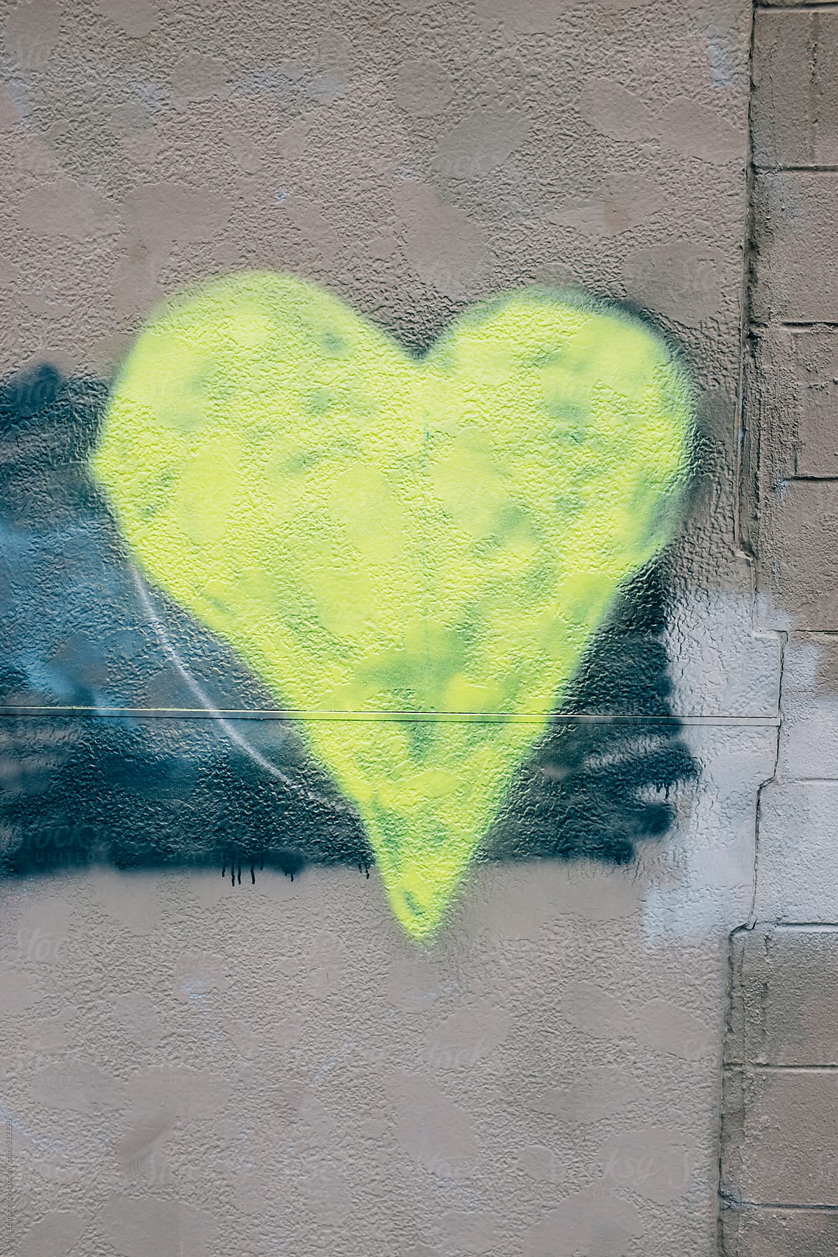 Yellow heart shape painted on wall of building