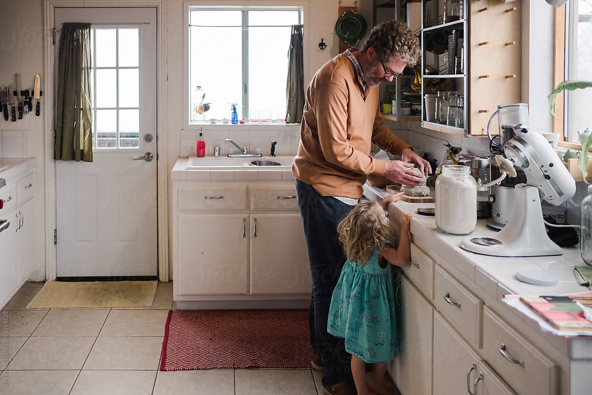stock photo of father and daughter making bread in the kitchen.