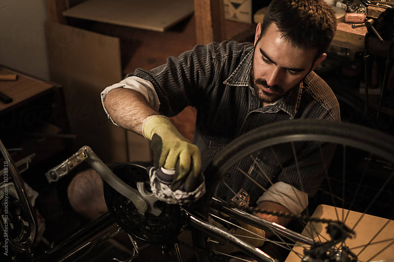 Young mechanic working on bike maintenance in his  rustic workshop.