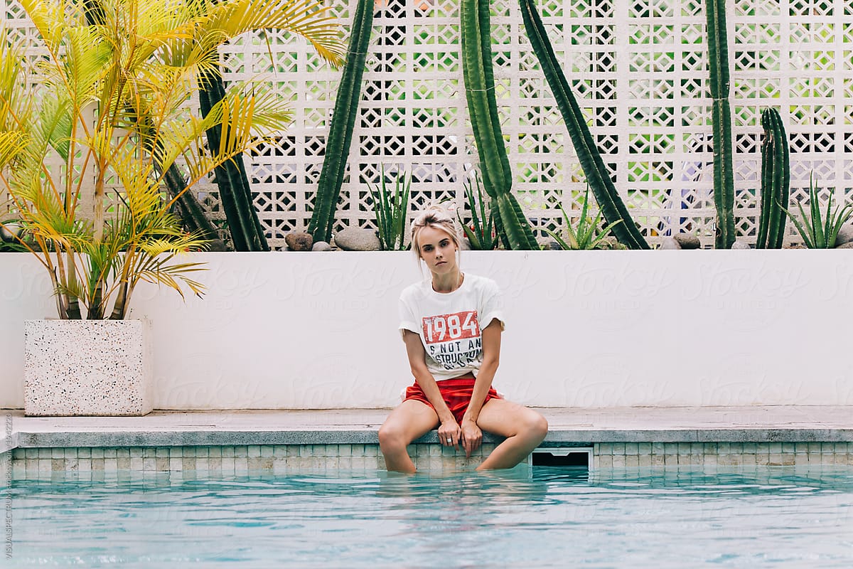 Young Pretty Rebel Girl Sitting by Swimming Pool in Tropical Beach Club