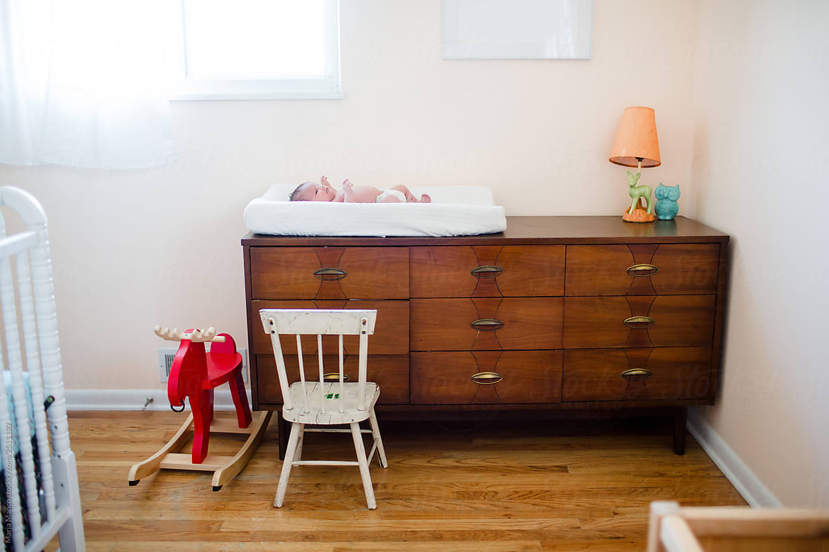 photo of baby on changing pad on dresser