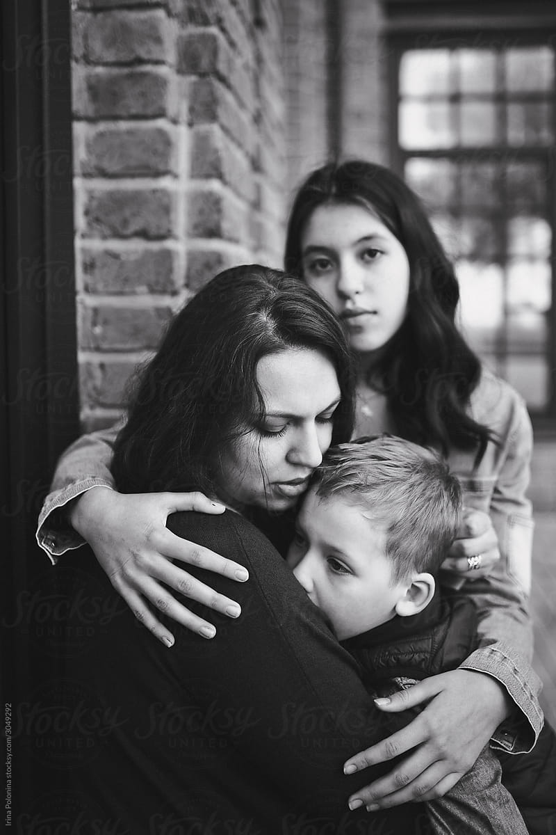 Black and white portrait of a mother with teenager daughter and little son.