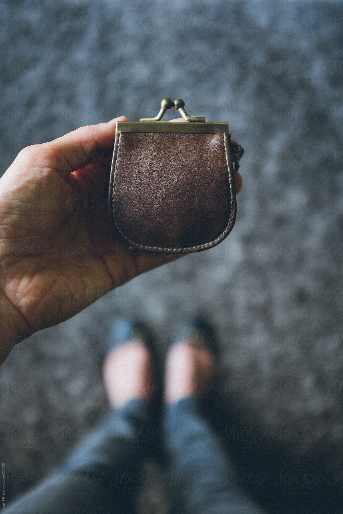Woman\'s hand holding a vintage coin purse.