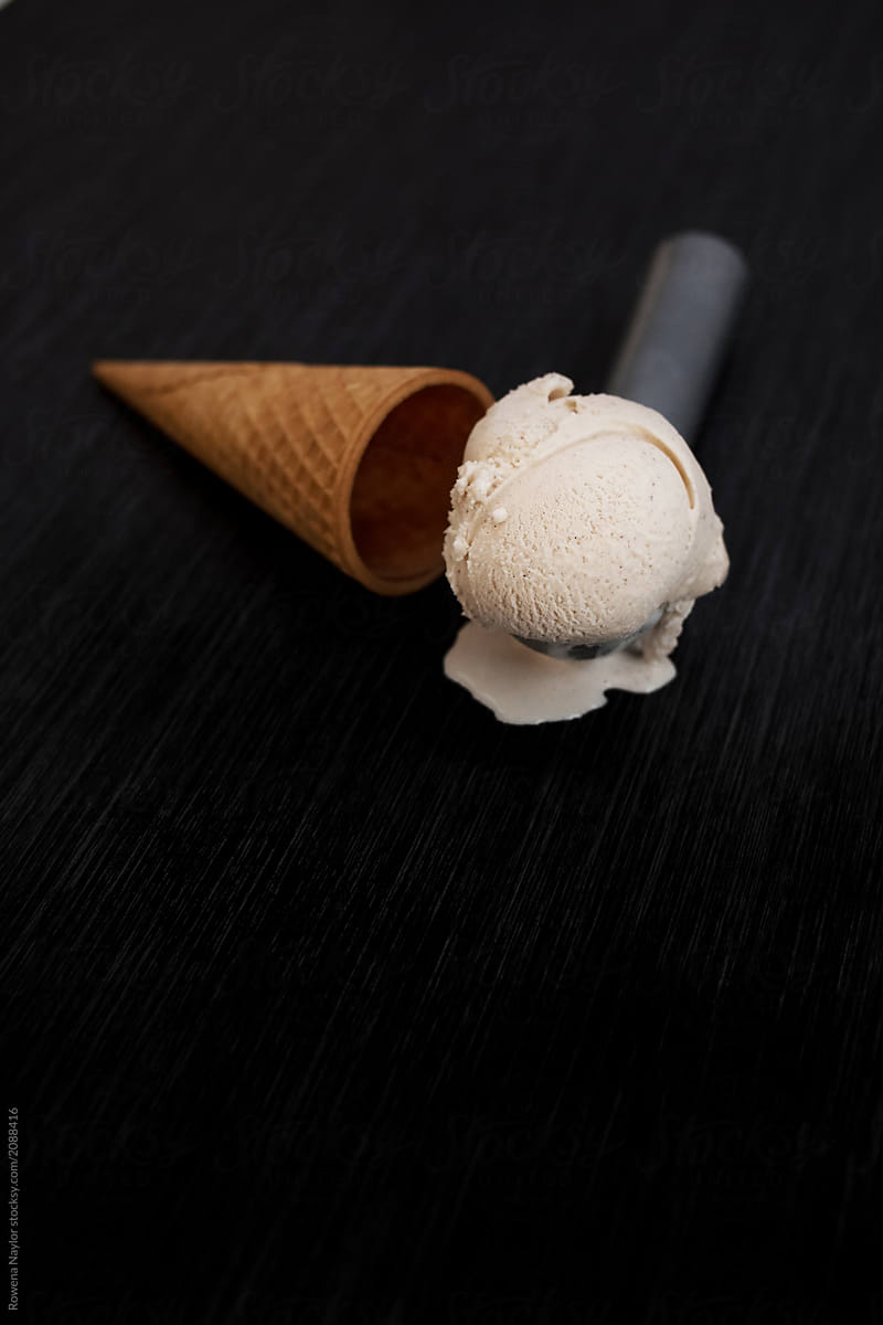Scoop of ice cream and waffle cone on black background