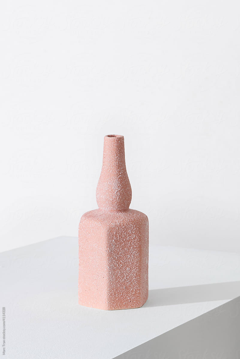 A single pink vase with a light pastel background
