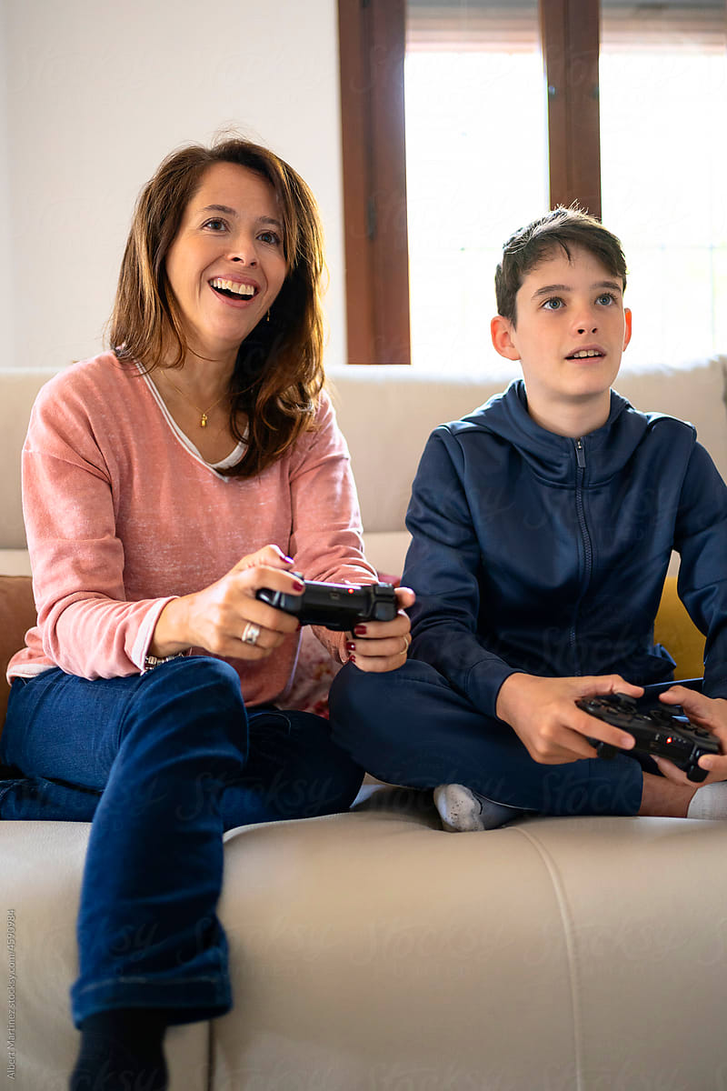 Cheerful boy with mother playing videogame