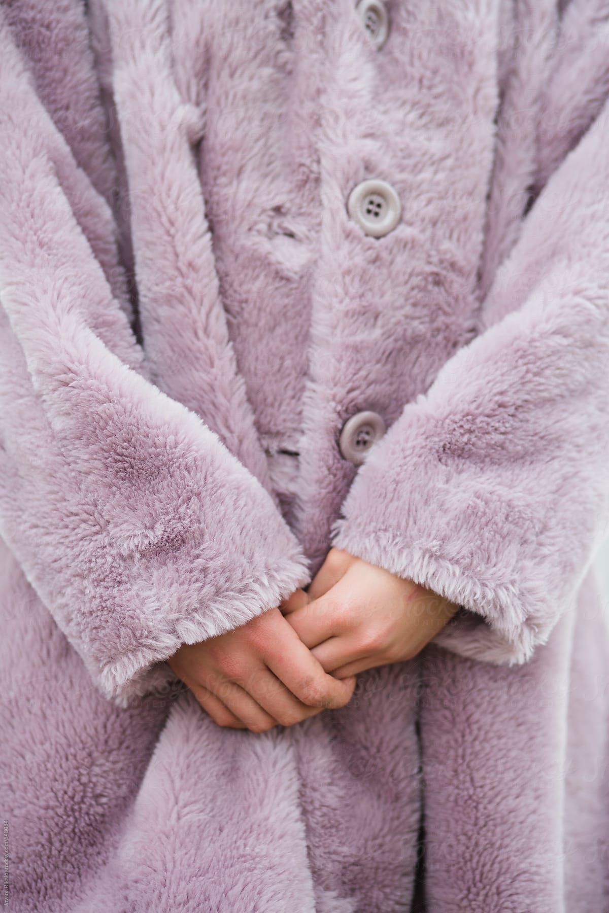 Close up of female hands and pink coat