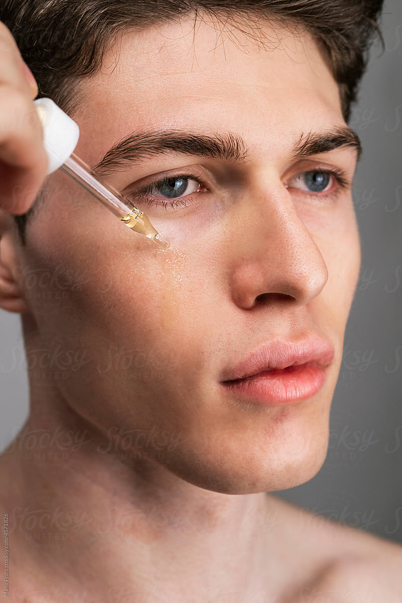 Serum dripping on male face, male skin care