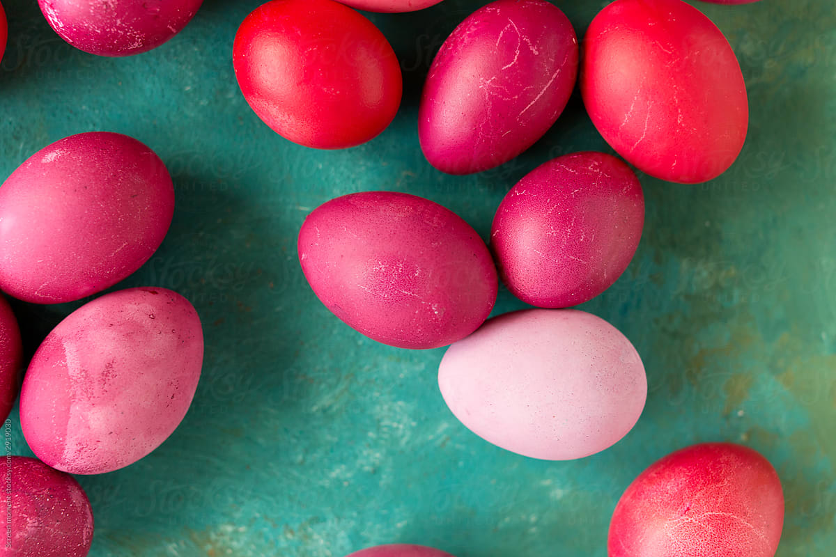 Pink and red Easter eggs on green background.