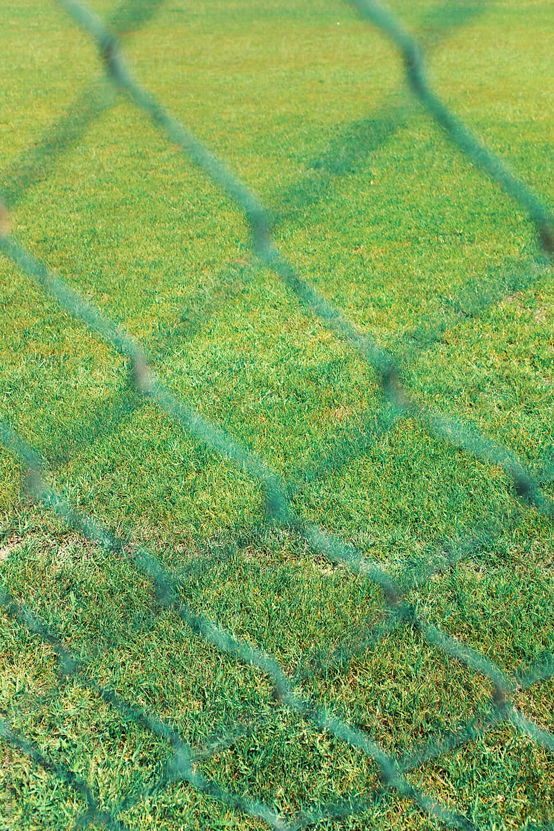 a chain-link fence and football field