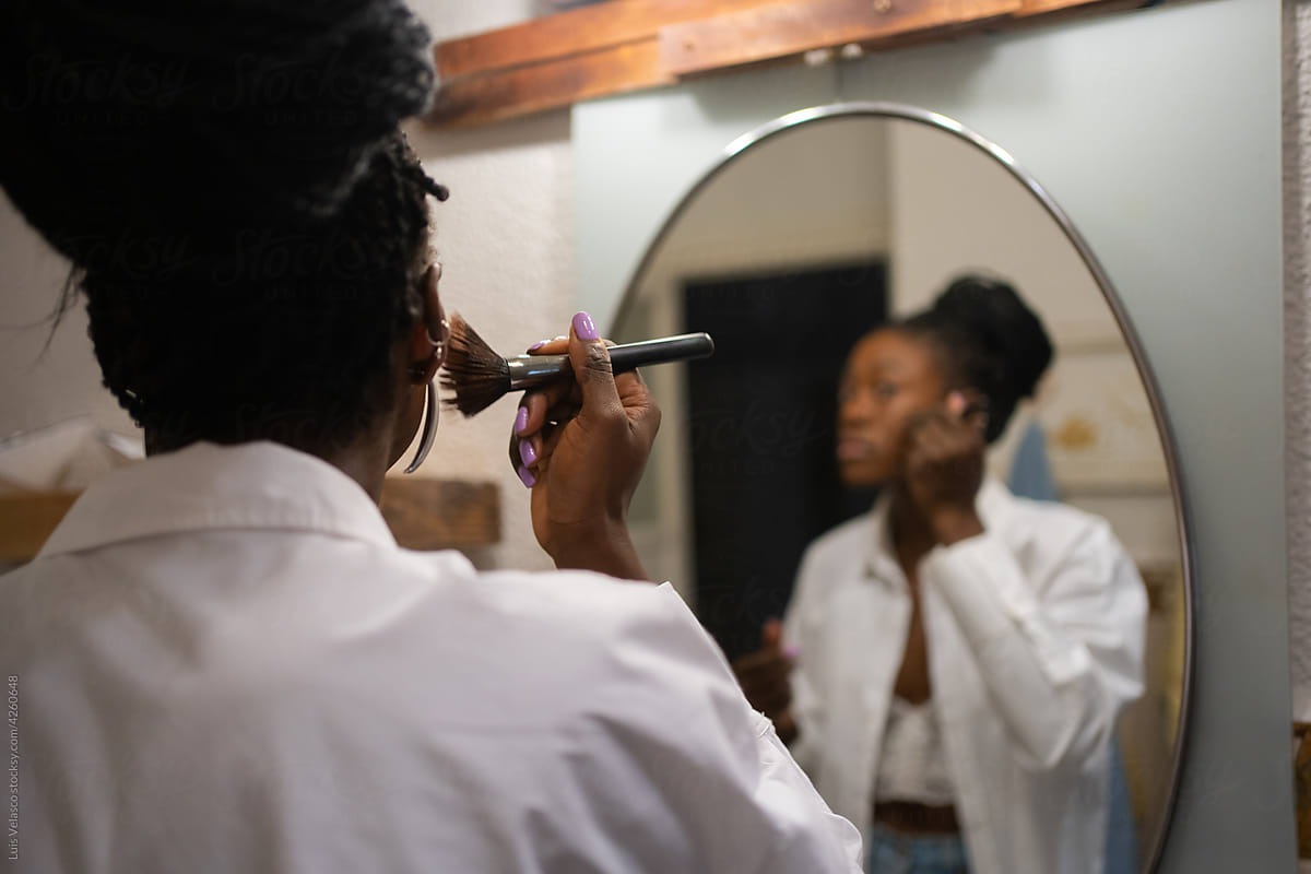 Woman Making Up With Brush In Front Of The Mirror.