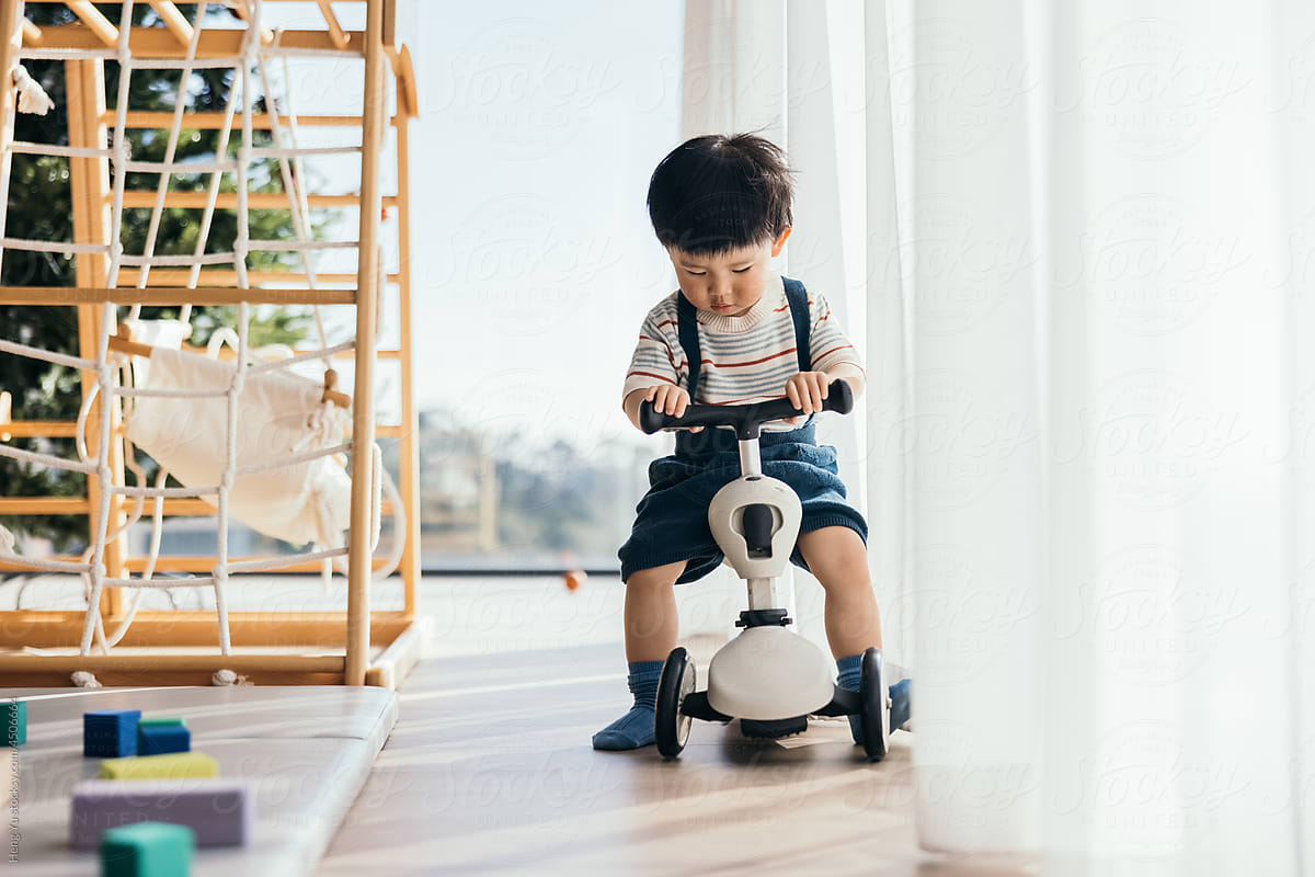 Little Boy Driving Balance Bike indoors