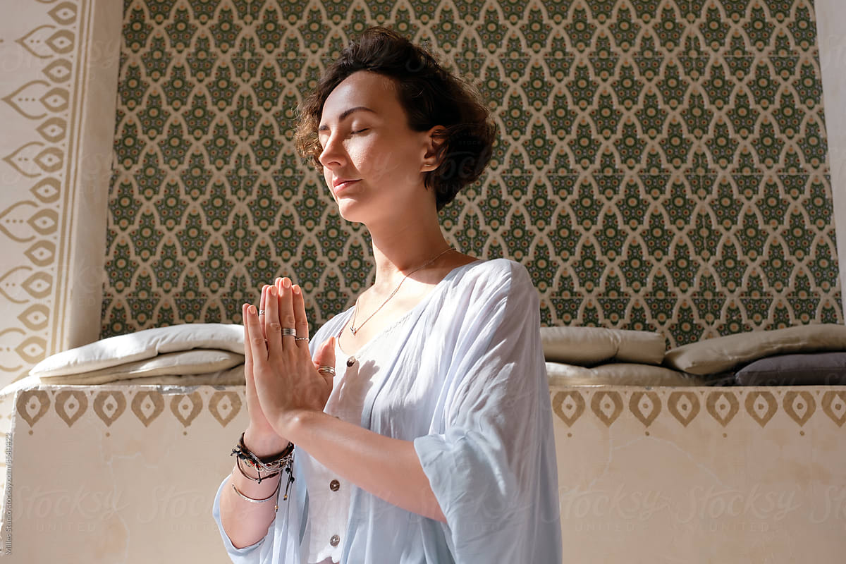 Woman meditating with clasped hands
