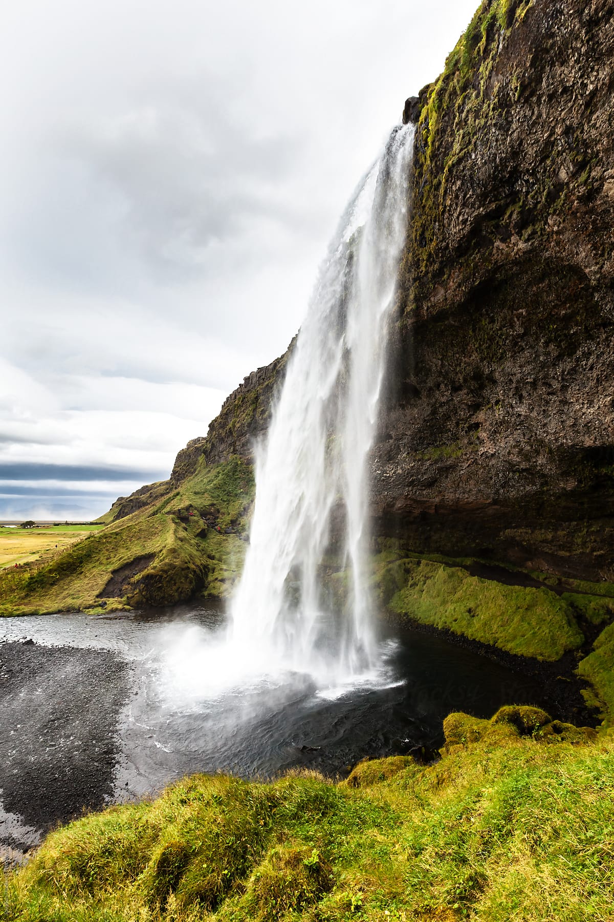 Waterfall in Iceland with heavy rain clouds in the sky