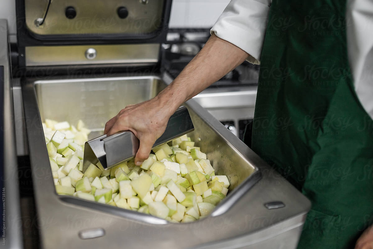 chef cooking vegetables in the industrial fryer in a kitchen