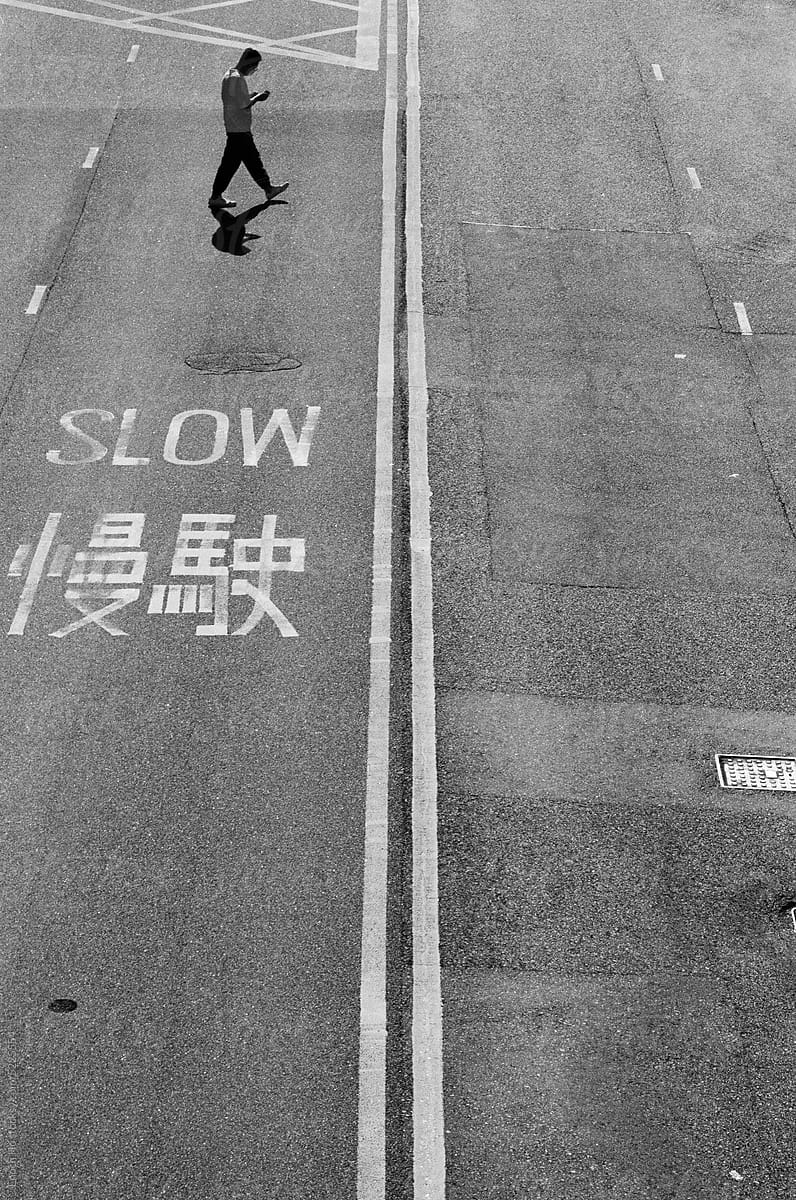 Man crossing street with slow sign